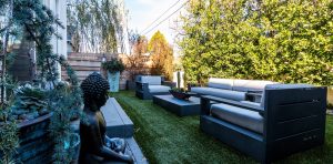 House backyard with couch and statues